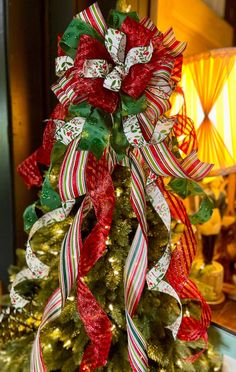 a christmas tree decorated with red, white and green ribbons