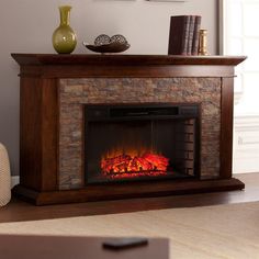 a fireplace with a fire in it and some books on the shelf next to it