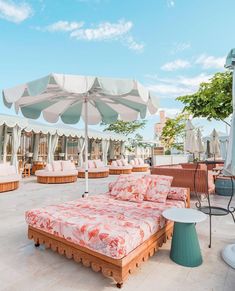 an outdoor seating area with sun umbrellas and lounge chairs in the background, on a sunny day