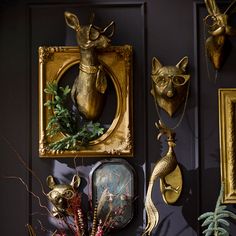 there are some gold deer heads on the wall and other decorative items in front of them