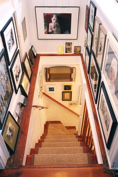 the stairs are lined with pictures and framed photographs