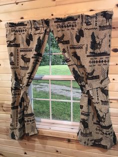 the window is decorated with black and white moose print curtains, along with matching valances