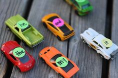 small toy cars sitting on top of a wooden table with magnets attached to them