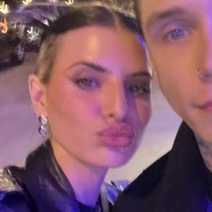 the man and woman are posing for a selfie in front of a christmas tree