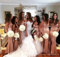 a group of women standing next to each other in front of a mirror holding bouquets