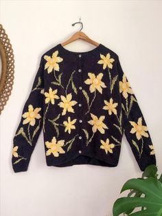 Love the whimsical cottagecore chic floral pattern of this chunky black knit oversized sweater from 90s era Talbots. This linen & cotton knit has a stark black base with bright butter yellow and marigold daffodil blossoms with sage green stems speckled all over it. Featuring a crew neckline and sweet little opalescent buttons this retro cardigan is perfect for layering up year round! #chunkysweater #90s #oversizedsweater #cottagecoreaesthetic Cottagecore Chic, Whimsical Cottagecore, Retro Cardigan, Knit Oversized Sweater, Retro Cardigans, Black Knit Cardigan, Butter Yellow, Oversized Knitted Sweaters