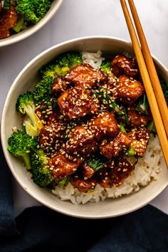 two bowls filled with meat and broccoli next to chopsticks