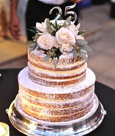 a three tiered cake with white flowers on top