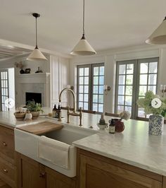 a kitchen with an island, sink and windows in the backround area is shown