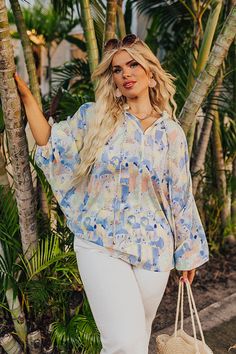 - Showcase your unique style with this trendy top! - Lightweight material featuring pastel hues and an abstract cityscape print - A ruffled v-cut neckline with a tie detail - ¾ length loose sleeves with elastic cuffs - A relaxed silhouette that ends in a high low hemline with a rounded back Abstract Cityscape, Loose Sleeves, Trendy Top, Pastel Hues, V Cut, V Cuts, Trendy Tops, High & Low, High Low