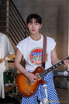 a young man is playing an electric guitar