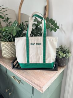 This bag is way too cute to get splashed by saltwater (or that spilled latte). But hey, that doesn't mean you can't enjoy the classic nautical vibes!   This tote is perfect for the landlubber with a love for ironic flair. Natural, navy, emerald, and baby blue are backordered until June 25. Why you'll love this bag: Spacious and sturdy: Made with durable canvas, this tote can handle all your daily essentials (phone, wallet, snacks... maybe even a pool noodle?). Classic design: The iconic boat tot Green Bag With Embroidered Logo For Everyday Use, Green Rectangular Canvas Bag For Weekend, Green Rectangular Canvas Bag For The Weekend, Embroidered School Tote Canvas Bag, Eco-friendly Green Bags With Letter Print, Eco-friendly Green Bag With Letter Print, High-end Square Monogram Canvas Bag, Boat Tote, Personalized Makeup Bags