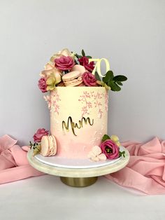 there is a cake with flowers on it and the number 10 in gold lettering that says mom