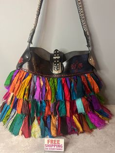 Show off your vintage style with this awesome rag bag purse! Vintage Multicolored Rag Bag Shoulder Purse - assorted colors of silk in strips, on a black leather purse. Red roses are stamped into the leather. The strap is black material on the inside, with a silver metal and clear rhinestone chain on top. Snap top. Inside pocket and zipper pocket.  Vintage / Used. Very good condition. Only damage is that the main purse zipper does not work. No other damage. Tag inside 100% SILK HAND LOOMED FABRIC Unique Multicolor Shoulder Bag For Everyday Use, Multicolor Fringe Shoulder Bag For Everyday Use, Unique Multicolor Travel Bag, Multicolor Fringe Bags For Festival, Multicolor Bohemian Bucket Hobo Bag, Multicolor Festival Bags With Fringe, Festival Multicolor Fringe Bags, Handmade Multicolor Vintage Bags, Everyday Multicolor Fringe Shoulder Bag