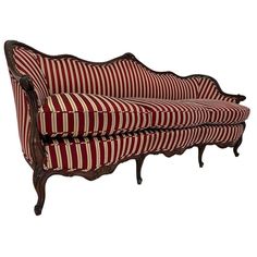 a red and white striped couch sitting on top of a wooden frame