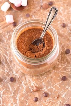 a spoon in a jar filled with cocoa powder