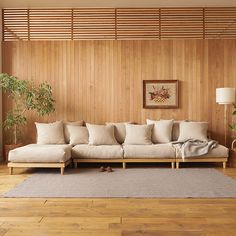 a living room with wood paneling and white couches on top of a wooden floor