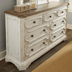 a white dresser with a mirror on top of it next to a rug and window