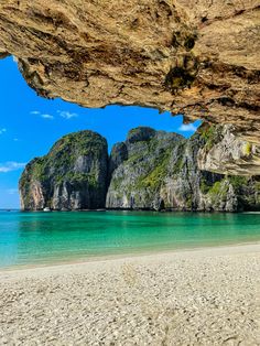 the beach is surrounded by large rocks and clear water