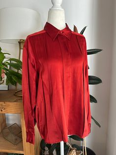 Dark rust or cinnamon colored, pleated, silk blouse. Blouse buttons down the front with hidden buttons, and at the wrist. In overall great condition with no notable flaws, no holes, stains, snags, holes, etc. Label reads, Talbots, size 6, 100% Silk.  Measurements Chest 36in/91.5cm Waist 34in/86.5cm Shoulders 14in/35.5cm Length 24in/61cm *Please keep in mind that unless otherwise noted, all items in my shop are used or previously owned, normal wear and tear is expected, flaws that are noted are range from major to minor, things like a missing stitch here or there my not be included. *Please read all policies on this and our policy page prior to making your purchase. *Please feel free to message me with any questions you may have as returns are not accepted. Response time is typically same d Classic Pleated Blouse For Fall, Fall Pleated Collared Blouse, Classic Pleated Tops For Fall, Fall Classic Pleated Tops, Fall Pleated Collared Tops, Formal Pleated Silk Blouse, Classic Pleated Button-up Top, Pleated Solid Color Blouse For Fall, Cinnamon Color