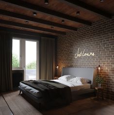 a bedroom with brick walls and flooring has a bed in front of a large window