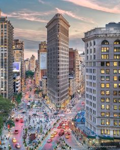 a city street filled with lots of traffic and tall buildings at dusk, as the sun sets