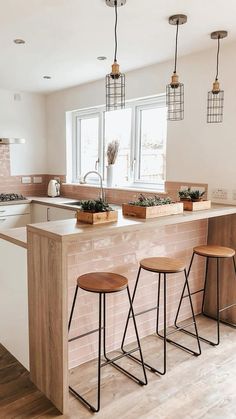 a kitchen with three stools next to a counter top and an island in the middle