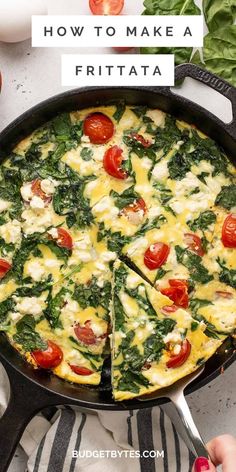 an omelet with spinach, tomatoes and cheese on it in a cast iron skillet