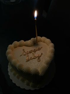 a heart shaped cake with a candle on top