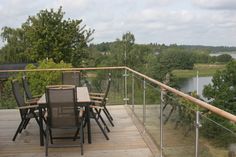 a table and chairs on a deck overlooking the water