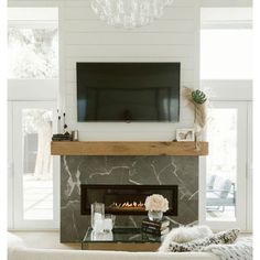 a living room with a fireplace and television mounted on the wall