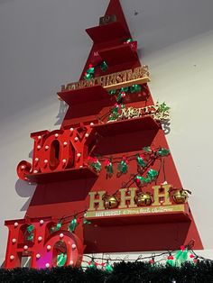 a large red christmas tree with lots of lights on it's sides and decorations