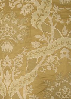 an old fashioned wallpaper with flowers and leaves on it's gold color scheme