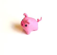 a pink toy pig sitting on top of a white table