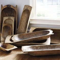 old wooden bowls and spoons are on the floor in front of an open window