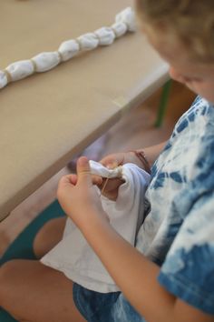 a young boy sitting on the floor playing with a toothbrush and toothpaste