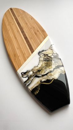 a wooden surfboard with black and white marble on it