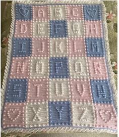 a crocheted blanket with the words happy birthday written in blue, pink and white