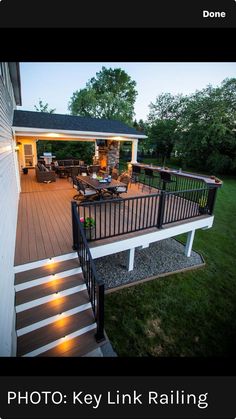 a deck with stairs and lights on it in front of a white house that has the words photo key link railing