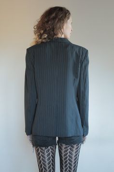 Best of 1990's classic minimalist cool Emporio Armani two button blazer. Great androgynous masculine style. Pin stripes on black background with white and grey stripes. Side front pockets. Fully lined. Slight shoulder pads give good shape to the shoulders. Label Emporio Armani, Made in Italy, Size 46. Dry clean only. 61% rayon, 30% pure wool, 5% nylon, 3% cotton, 1% polyester. Lining 100% rayon. Very good vintage condition with no fabric or sewing flaws. Measurements Shoulders 44cm/ Chest 102cm/ Fall Office Pinstripe Suits, Fall Pinstripe Office Suits, Classic Long Sleeve Blazer With Vertical Stripes, Winter Pinstripe Suits For Workwear, Winter Pinstripe Suit For Workwear, Winter Pinstripe Suits For Work, Fitted Blazer With Vertical Stripes For Spring, Fitted Pinstripe Blazer For Spring, Classic Pinstripe Blazer For Winter