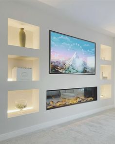 a flat screen tv mounted to the side of a wall next to shelves filled with vases