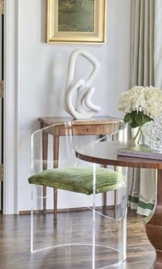 a dining room table and chairs with flowers in vases on the end tables next to them