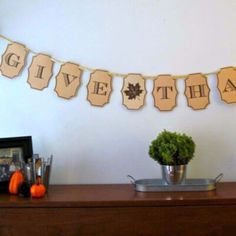 a table topped with a potted plant next to a sign that says give thanks