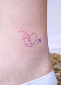 a small tattoo on the ankle of a woman's foot with two hearts and an airplane