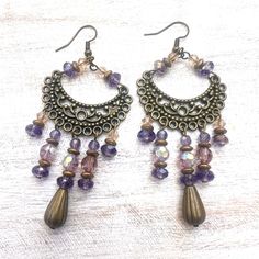 These are one of my all-time favorite designs. Starting with an arced bronze tone chandelier component, I added several shaded of purple and lavender round and faceted glass beads and finished with corrugated bronze tone teardrops. These beautiful chandelier earrings are great for those of us with a long quaff as they drape close to the shoulder.

All metals are nickel and lead free. Suede Bracelet, Formal Earrings, Earring Inspiration, Prom Earrings, Diy Earring, Bronze Chandelier, Bronze Earrings, Multi Strand Bracelet, Bottle Necklace