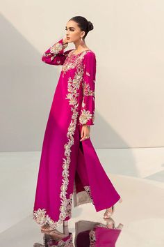 Mexican pink raw silk long shirt paired seamlessly with slim straight trousers. Elevate your formal attire with this elegant ensemble, perfect for special occasions, evening events, and black-tie affairs. Discover designer formal wear featuring sequins and long dresses for a sophisticated and stylish look. Explore the allure of elegant formal dresses suitable for various occasions, from cocktail parties to black-tie events.In the enchanting embrace of Mexican pink, an exquisite ensemble effortle New Party Wear Dress, Raw Silk Dress, Heavy Dresses, Fancy Suit, Womens Trendy Dresses, Pakistani Fancy Dresses, Pakistani Fashion Party Wear, Pakistani Bridal Dresses, Simple Pakistani Dresses