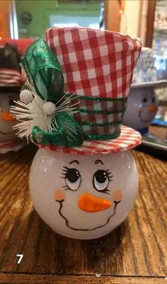 a snowman ball with a red and white checkered hat on it's head