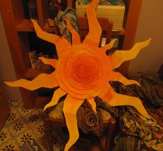 an orange sunflower sitting on top of a wooden table next to a book shelf