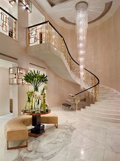 a large foyer with marble flooring and chandelier hanging from the second story