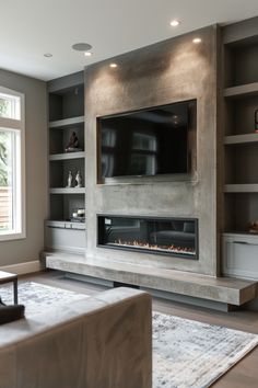 a living room with a fireplace and built in bookshelves next to a large window